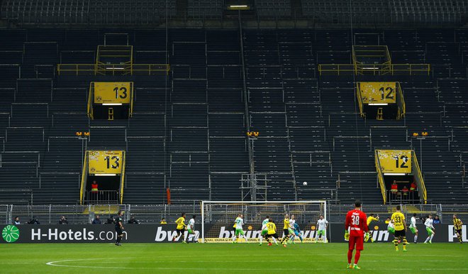 Takole sta pred tremi leti igrala Borussia in Wolfsburg zavoljo ene tekme prepovedi igranja pred navijači, ki je doletela Dortmundčane. Podoben prizor se obeta danes na porurskem derbiju. FOTO: Reuters