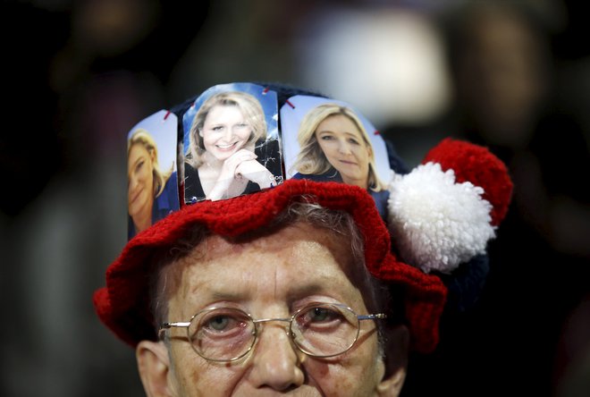 A supporter wears a cap with pictures of Marine Le Pen (R) and Marion Marechal-Le Pen (C), French National Front political party candidates for the second round of the regional elections in Marseille, France, December 9, 2015. REUTERS/Jean-Paul Pelissier       TPX IMAGES OF THE DAY      - GF10000260240