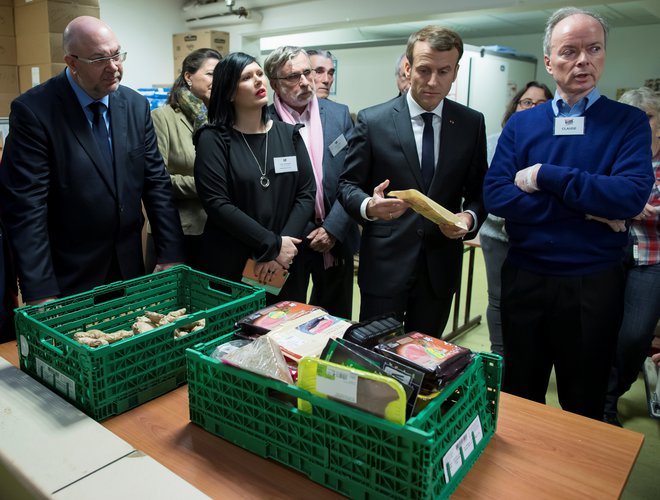 Predsednik Emmanuel Macron v človekljubni razdelilnici hrane Les Restos du Coeur. FOTO: Reuters