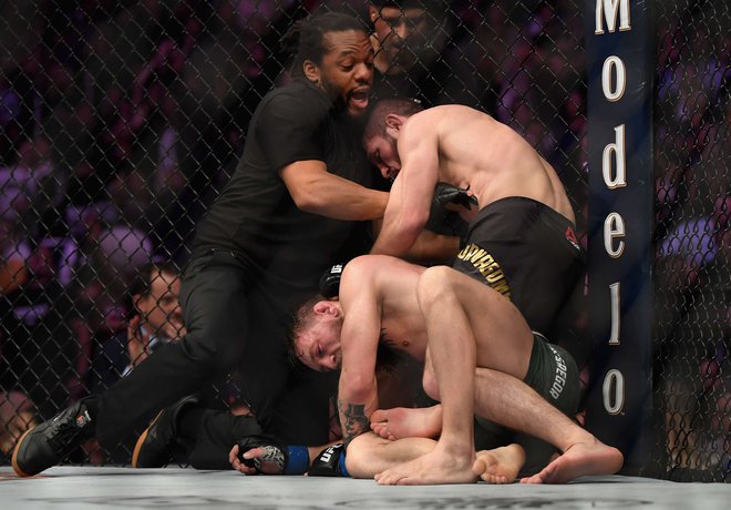 Habib Nurmagomedov (zgoraj) je z davljenjem v četrti rundi prisilil k vdaji Conorja McGregorja. FOTO: AFP