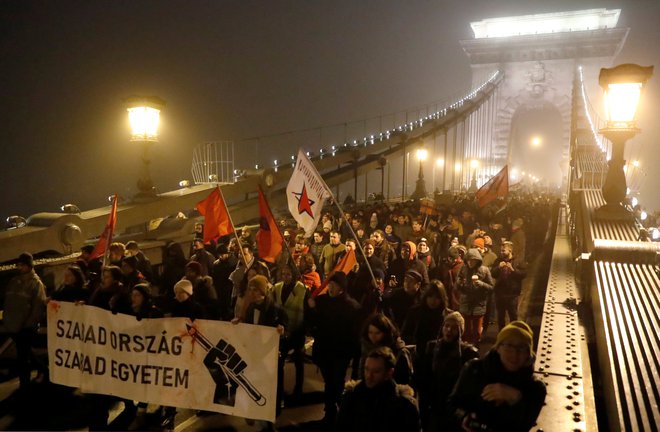 People march at the Chain Bridge during a protest against the new labour law in Budapest, Hungary, December 13, 2018. The banner reads 