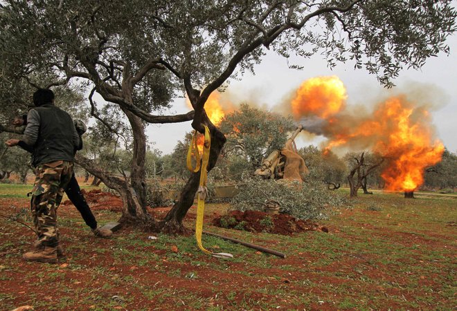TOPSHOT - Members of Syria's opposition "National Liberation Front" fire heavy artillery guns at government forces in the village of Talhiyeh near the town Taftanaz in northeastern Idlib province, from another position on February 28, 2020. (Photo by Abdulwajed HAJ ESTEIFI / AFP)