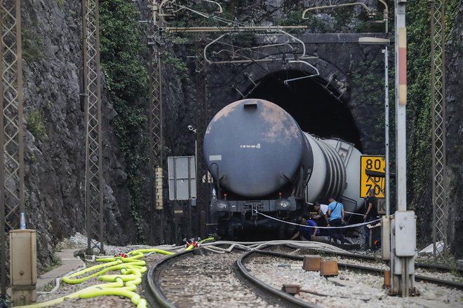 Od kompozicije 18 vagonov se je pri Hrastovljah iztirilo šest vagonov in se nagnilo na steno predora. Po iztirjenju je začel iztekati kerozin, in sicer ga je v zemljo odteklo okoli 9000 litrov. Ta kerozin še naprej ogroža vodni vir Rižane. FOTO: Uroš Hocevar/Delo