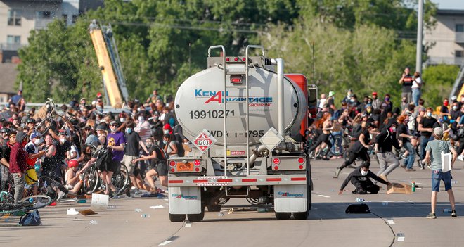 V Minneapolisu, kjer je Floyd tragično umrl med aretacijo, je voznik tovornjaka cisterne zapeljal proti množici protestnikov, ki je korakala po eni od glavnih cest. Protestniki so se še pravočasno umaknili, nato pa voznika cisterne potegnili iz vozila in ga pretepli. S poškodbami je bil odpeljan v bolnišnico. Motiv dejanja še ni znan. FOTO: Eric Miller/Reuters