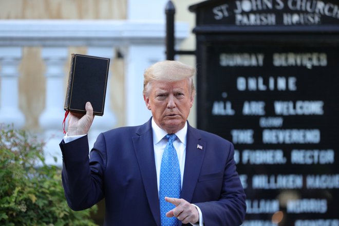 Ameriški predsednik Donald Trump z Biblijo v roki po razganjanju protestnikov pred Belo hišo. FOTO: Tom Brenner/Reuters