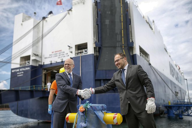 Minister Jernej Vrtovec in predsednik uprave Dimitrij Zadel sta simbolično privezala ladjo Neptun Kefalonia, ki bi lahko pripeljala skoraj 3000 avtomobilov, a jih je v Koper tokrat precej manj. FOTO: Blaž Samec/Delo