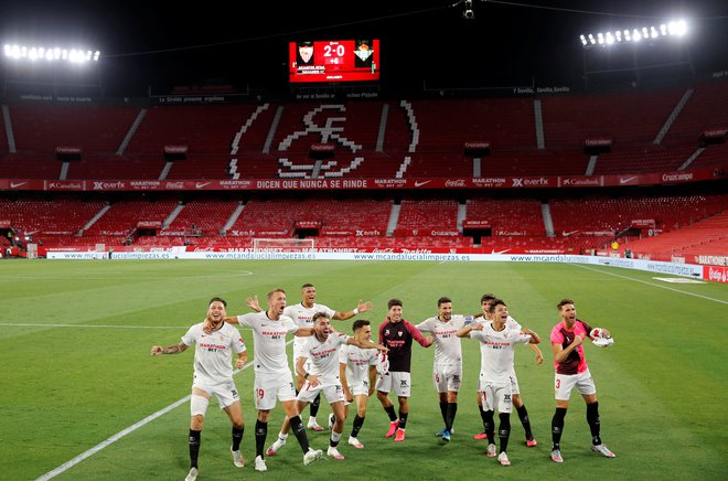 Nogometaši Seville so se na praznem štadionu veselili zmage v mestnem derbiju proti Betisu. FOTO: Marcelo del Pozo/Reuters