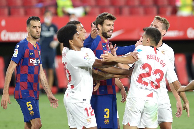 Gerard Pique (Barcelona) se je med tekmo takole jezil na Sergia Reguilona (Sevilla). FOTO: Cristina Quicler/AFP