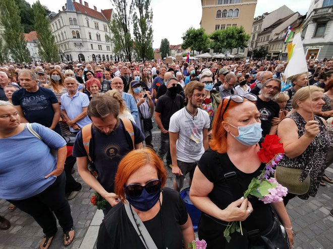 Veliko ljudi je na Prešernovem trgu nosilo cvetje. FOTO: Foto Jože Suhadolnik/Delo