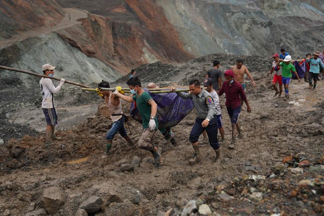 Reševalci iz blata odkopavajo trupla umrlih. FOTO: Zaw Moe Htet/AFP