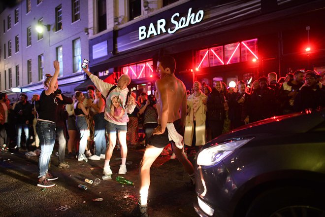 Pubi in restavracije so bile po večini polni, saj so si ljudje po več tednih zaželeli druženja. FOTO: Justin Tallis/AFP