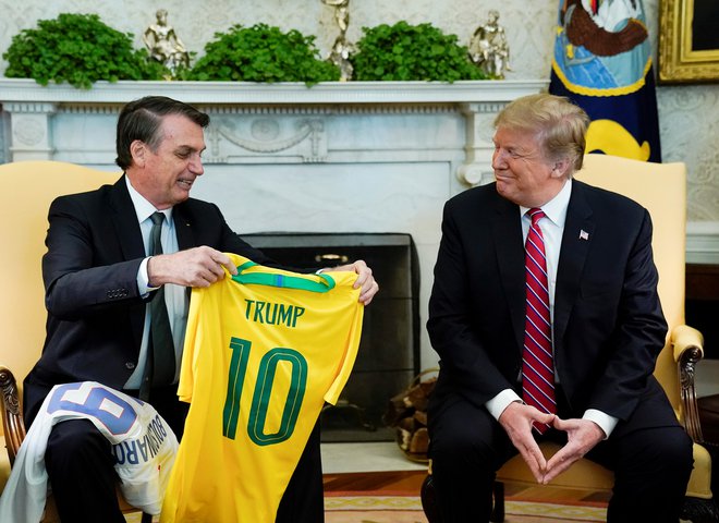 Brazilski predsednik Jair Bolsonaro in njegov ameriški kolega Donald Trump sta včerajšnji obisk ozaljšala z izmenjavo nogometnih majic. Trump je dobil Peléjevo desetico. FOTO: Reuters