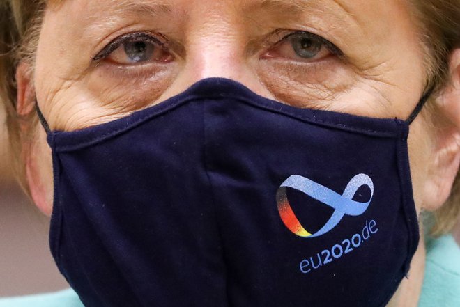 German Chancellor Angela Merkel wears a protective face mask with the logo of Germany&#39;s EU council presidency as she attends a plenary session in Brussels on July 8, 2020, upon the presention of the German programme for EU presidency. - The German presidency started on July 1, and will last until December 31, 2020. (Photo by YVES HERMAN / POOL / AFP) Foto Yves Herman Afp