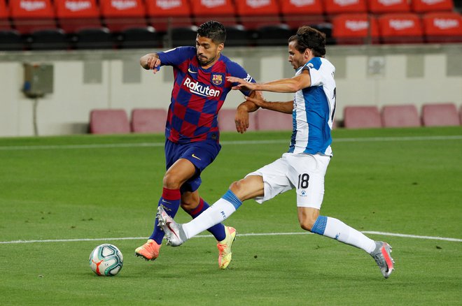 Barcelonin adut Luis Suarez in Espanyolov nogometaš Leandro Cabrera med katalonskim derbijem. FOTO: Albert Gea/Reuters