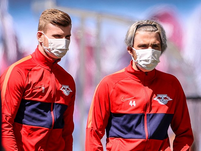 Prvi zvezdnik Leipziga Timo Werner in rekonvalescent Slovenec Kevin Kampl (desno) sta se držala zdravstvenih navodil in z maskami opravila ogrevanje pred dvobojem s Freiburgom.  FOTO: Reuters