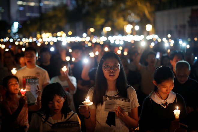 Po podatkih organizatorjev se je jubilejne večerne komemoracije v parku Victoria v Hongkongu udeležilo 180.000 ljudi. FOTO: Tyrone Siu/Reuters