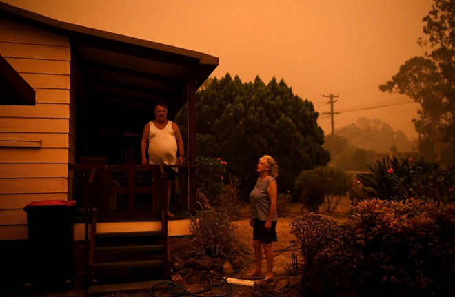 Nancy Allen and Brian Allen stand outside while the garden hoses wet down the house as high winds push smoke and ash from the Currowan Fire towards Nowra, New South Wales, Australia January 4, 2020. REUTERS/Tracey Nearmy  REFILE - CORRECTING DATE - RC229E93096N
