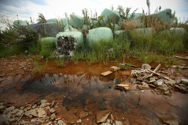 Okoli razpadajočih odpadkov se nabira onesnažena voda, ki odteka v podtalnico in na bližnja kmetijska zemljišča. FOTO: Jure Eržen