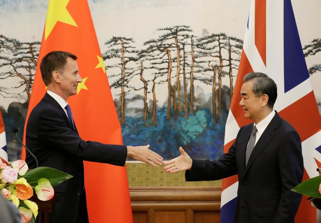 Kitajski zunanji minister Wang Yi si ni vzel k srcu prvega spodrsljaja britanskega zunanjega ministra Jeremyja Hunta (levo). FOTO: Reuters
