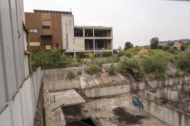 Gradbena jama na območju Tobačne bo zevala še najmanj pol leta. Usoda prodaje nepremičnin propadlega Imosa-G je zdaj v rokah ustavnih sodnikov. Foto Voranc Vogel