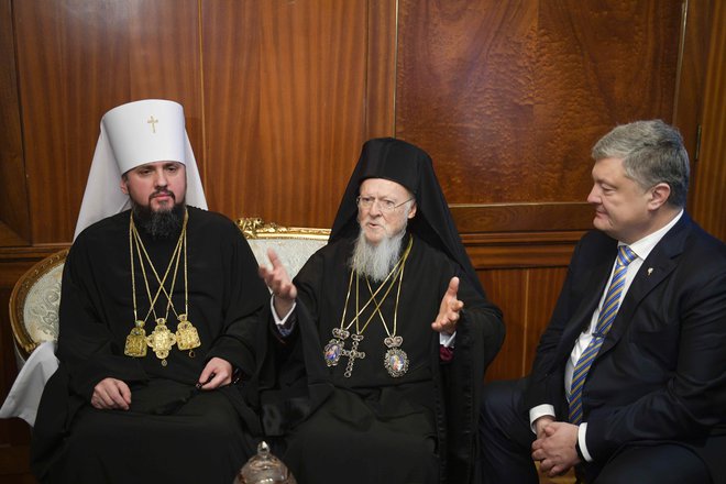 Patriarh Bartolomej ob metropolitu Epifaniju in Petru Porošenku. FOTO: Reuters