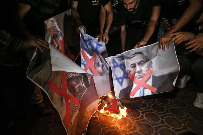 Palestinci v južni Gazi so v znak nestrinjanja s &raquo;priložnostjo stoletja&laquo;, kot je načrt poimenoval Jared Kushner, zažgali plakate s podobami ameriškega predsednika Trumpa, izraelskega premiera Netanjahuja in kralja Bahrajna Hamada al-Kalife. Foto: Said Khatib AFP