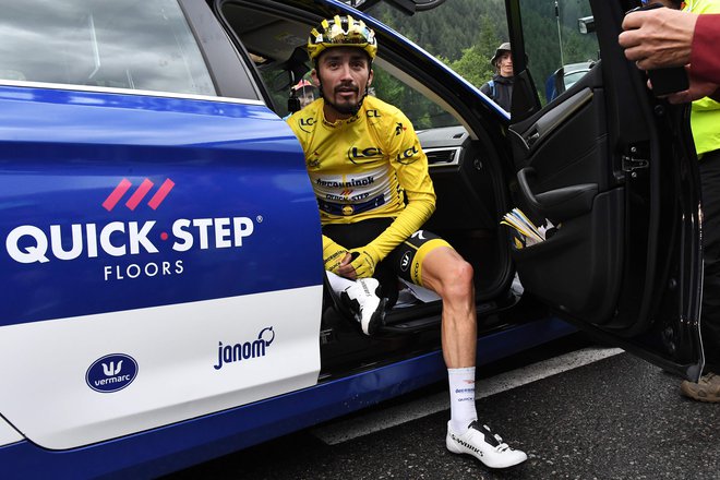 TOPSHOT - France's Julian Alaphilippe, wearing the overall leader's yellow jersey reacts after the race was stopped due to bad weather conditions in the last 20 kilometers during the nineteenth stage of the 106th edition of the Tour de France cycl