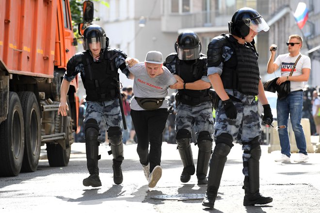 Policija med prijetjem enega od opozicijskih protestnikov.&nbsp; FOTO: Kirill Kudryavtsev/AFP