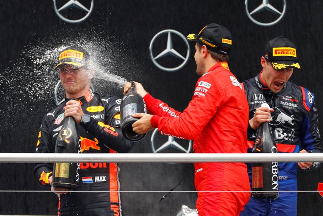 Drugouvrščeni Sebastian Vettel (na sredini) je s šampanjcem poškropil zmagovalca Maxa Verstappna (levo). Tretji je bil presenetljivo Rus Danil Kvjat.<br />
Foto Reuters