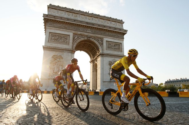 Egan Bernal je v rumeni majici užival med vožnjo ob pariškem Slavoloku zmage. Foto Reuters