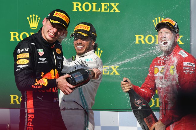 Lewis Hamilton (v sredini) je takole zalil Maxa Verstappna, tudi Sebastianu Vettlu je prijal šampanjec, potem ko je ugnal Charlesa Leclerca. FOTO: AFP
