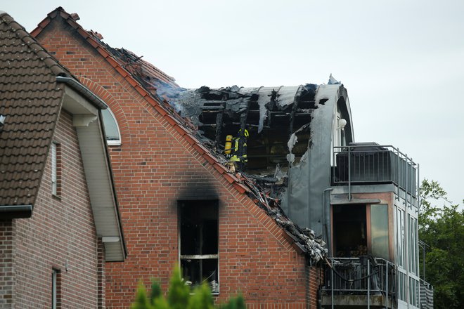 Po strmoglavljenju nje streho večstanovanjske hiše zajel požar. FOTO: Leon Kuegeler/Reuters