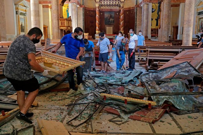 Tudi sakralna arhitektura v Bejrutu je poškodovana. V maronitski cerkvi svetega Jurija so takole reševali opremo. Foto Joseph Eid/AFP