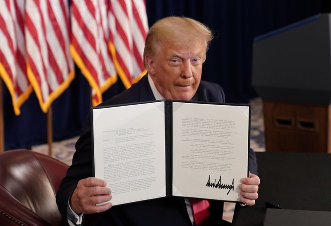 Donald Trump razkazuje svoj podpis pod izvršilnim zakonom.&nbsp;Foto Joshua Roberts Reuters