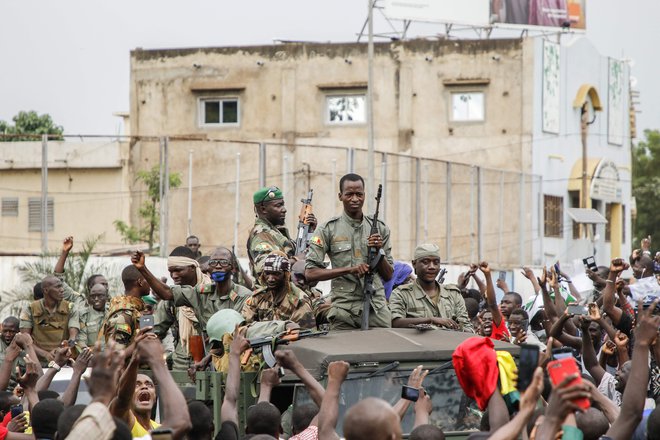 Prebivalstvo pozdravlja vojake, ki paradirajo po ulicah Malija. FOTO: Stringer/AFP