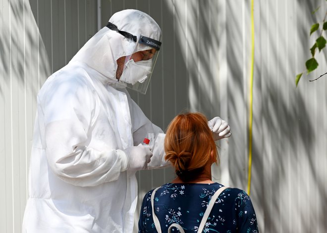 Medicinski delavec v zaščitni opremi med testiranjem na covid-19 v Zagrebu, ki je eno od žarišč koronavirusa na Hrvaškem. FOTO: Denis Lovrovic/Afp