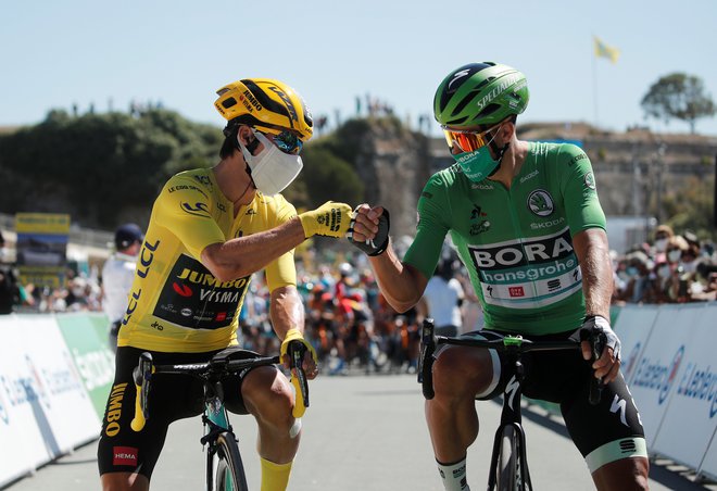 Kolesarski ples v maskah, rumeni Primož Roglič in zeleni Peter Sagan. FOTO: Benoit Tessier/Reuters