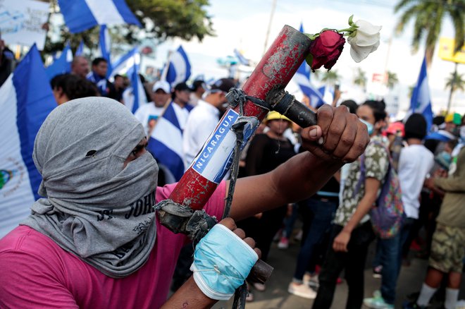 Protestnik z doma narejenim minometom. FOTO: Oswaldo Rivas/Reuters