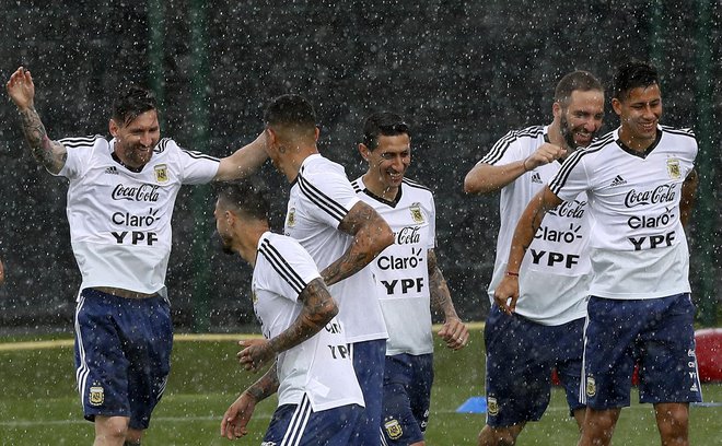 Lionel Messi (levo), Angel Di Maria, Gonzalo Higuain in soigralci prešerno vadijo tudi v dežju.<br />
Foto AP