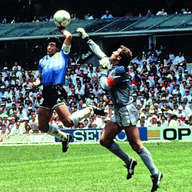 Diego Maradona je na SP 1986 v četrtfinalu preskočil angleškega vratarja Petra Shiltona, a žogo vendarle potisnil v mrežo z levo roko. FOTO: Dokumentacija Dela