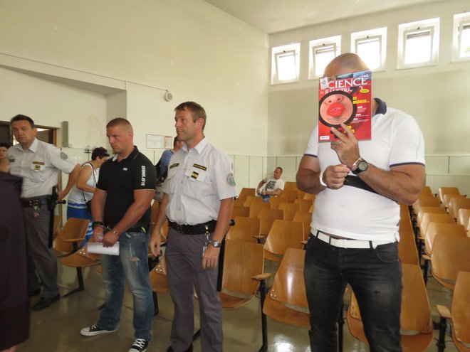 Obtožena Emir Hasičić (levo) in Simon Lucaj, ki se skriva za revijo, zanikata vpletenost v prepodajo drog. FOTO: Mojca Marot