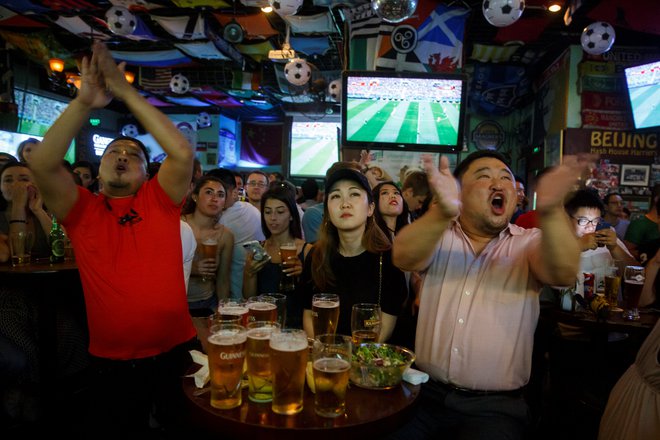 Kitajski ljubitelji nogometa med ogledom uvodne tekme SP med Rusijo in Savdsko Arabijo v enem od pekinških barov. FOTO: Reuters