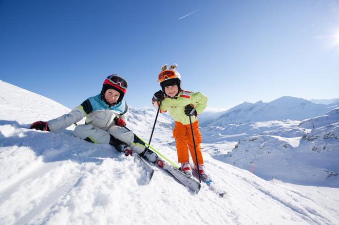 happy children in skiing outfit in snowy mountains