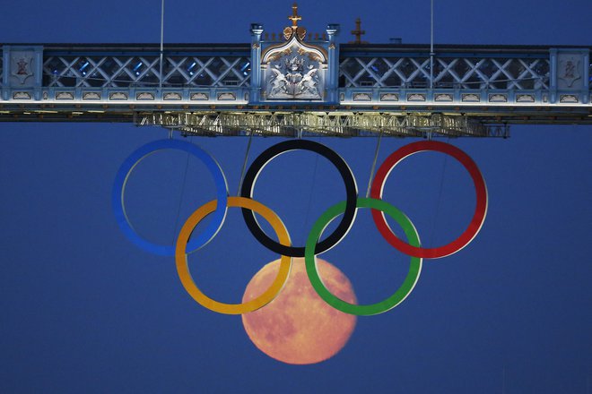 The full moon rises through the Olympic Rings hanging beneath Tower Bridge during the London 2012 Olympic Games August 3, 2012.  REUTERS/Luke MacGregor  (BRITAIN - Tags: SPORT OLYMPICS ENVIRONMENT CITYSPACE)