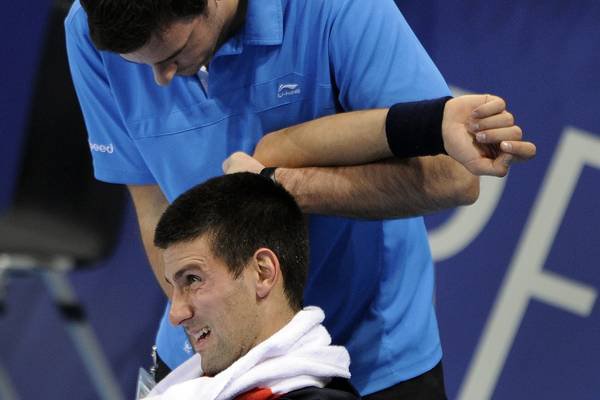 Serbia's Novak Djokovic receives medical treatment during his semi-final match against Japan's Kei Nishikori at the Swiss Indoors ATP tennis tournament match on November 5, 2011 in Basel. AFP PHOTO / FABRICE COFFRINI
