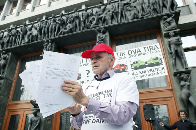 Vili Kovačič pred parlamentom z podpisi za zaustavitev gradje dugega tira. FOTO:&nbsp;Mavric Pivk/Delo