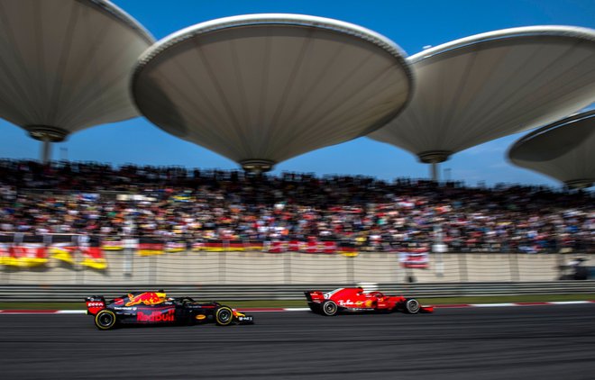 Daniel Ricciardo je v desetih krogih na svežih gumah prišel s šestega na prvo mesto, na ravnini je švignil mimo Sebastiana Vettla. FOTO: AFP