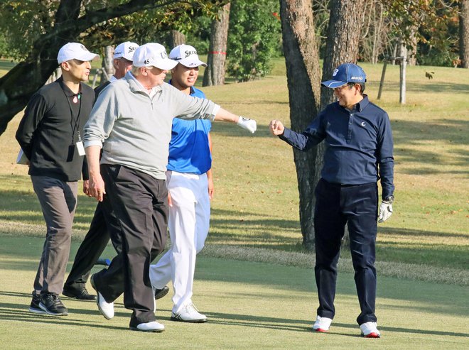 Donald Trump pozdravlja dobro potezo Šinza Abeja (desno) med njuno zadnjo partijo golfa. FOTO: Reuters