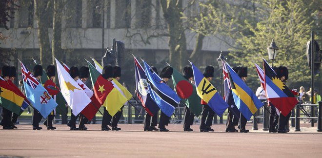 Častna straža pred Buckinghamsko palačo nosi zastave držav članic Skupnosti narodov. FOTO: Gareth Fuller/PA via AP