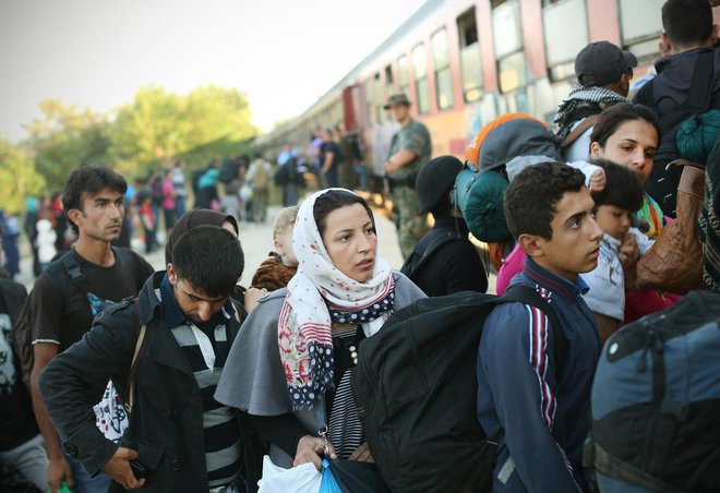 Begunci iz begunskega centra vstopajo na prvi jutranji vlak proti Srbiji. Gevgelija, Makedonija 28.avgusta 2015..[begunci,družine,vlaki,ženske,begunski centri]